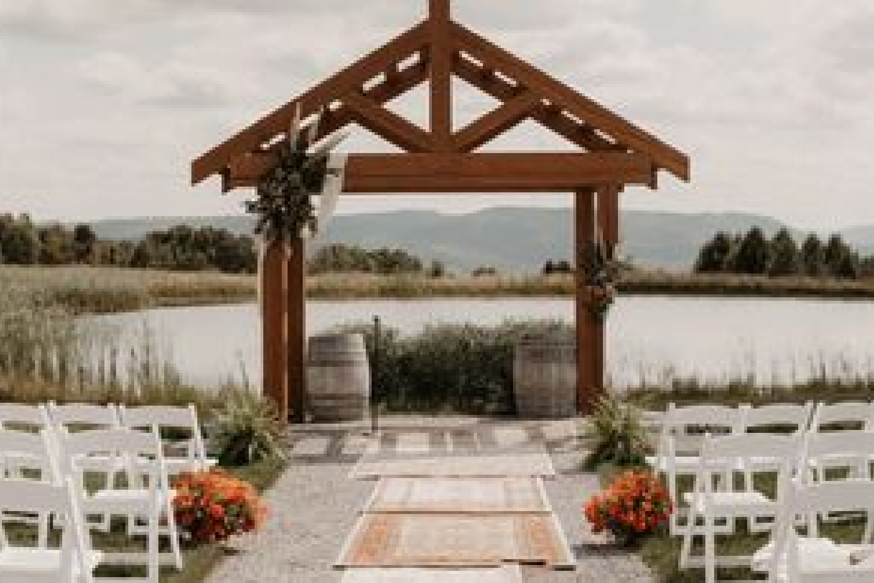 A wedding ceremony with an outdoor setting and flowers.