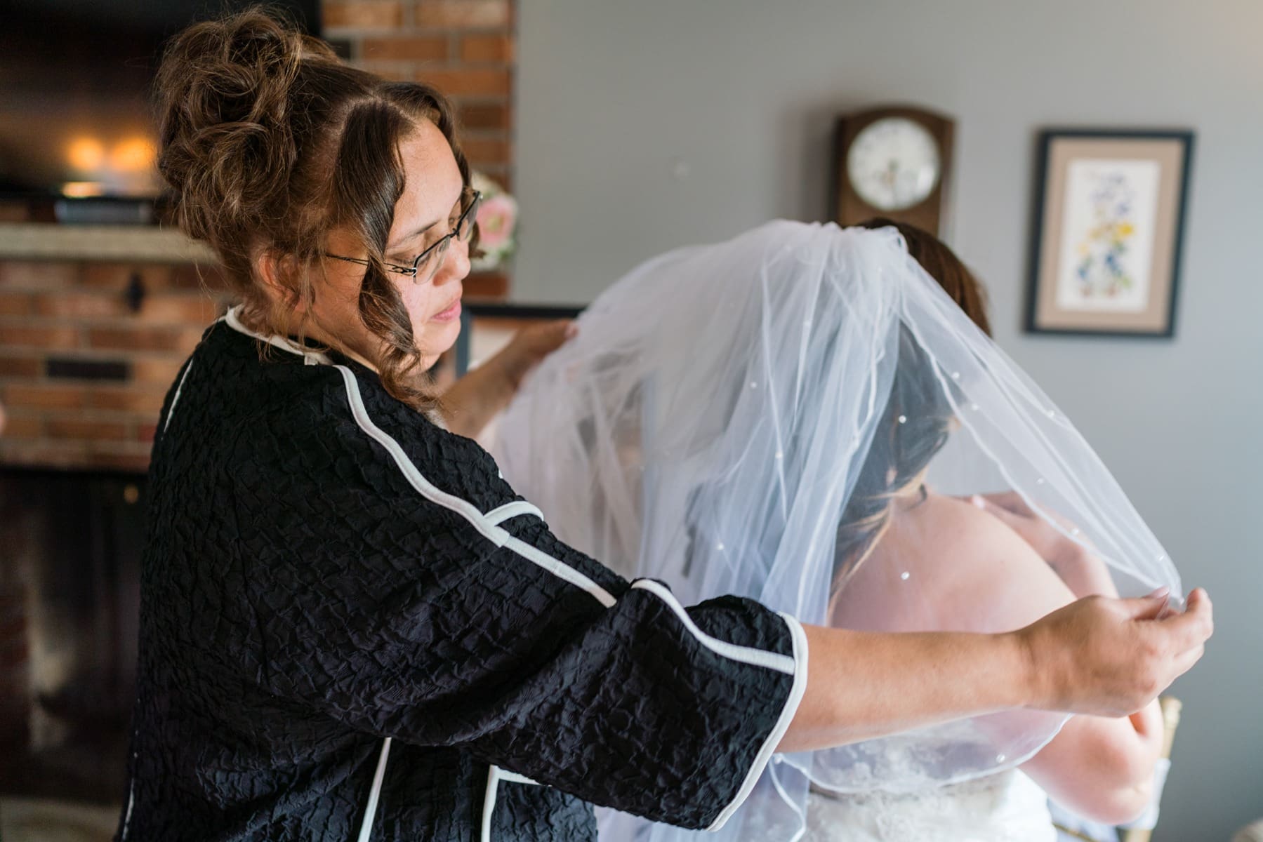 A woman in black jacket holding white veil.