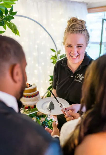 A woman holding a plate with a cake on it.